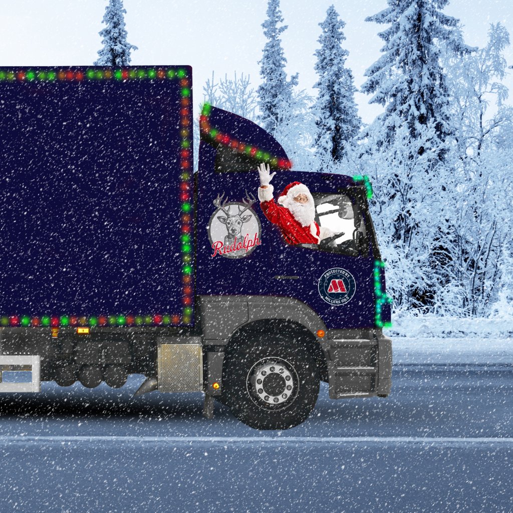 Lorry with santa driving and a millers oils sticker on on the roads when snowy