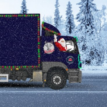 Lorry with santa driving and a millers oils sticker on on the roads when snowy