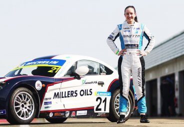 Alisha Palmowski in front of millers oils x ginetta racing car