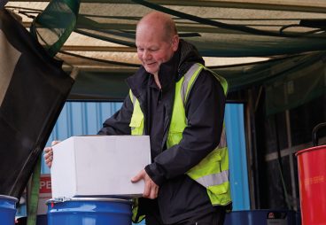 Image of Mark Grundy our HGV driver, loading a box into his truck.